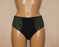 A pair of women's classic panties, featuring a green minimalistic pattern with a hexagonal design.