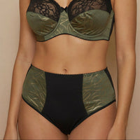 Woman wearing a green and black lingerie against a beige background