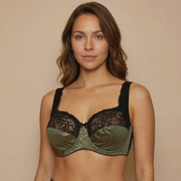 Woman wearing a green and black lingerie set against a beige background