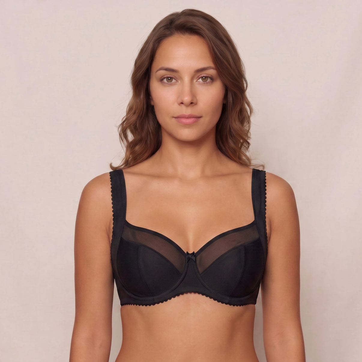 Woman wearing a black bra against a plain background