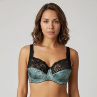 Woman wearing a black and teal lace bralette against a plain background