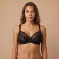 Woman wearing a black lace bra against a beige background