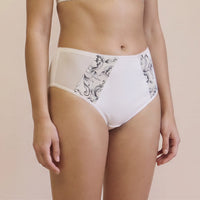 Light beige high-waisted briefs with black floral lace panels on the sides, shown on a model against a solid beige background.