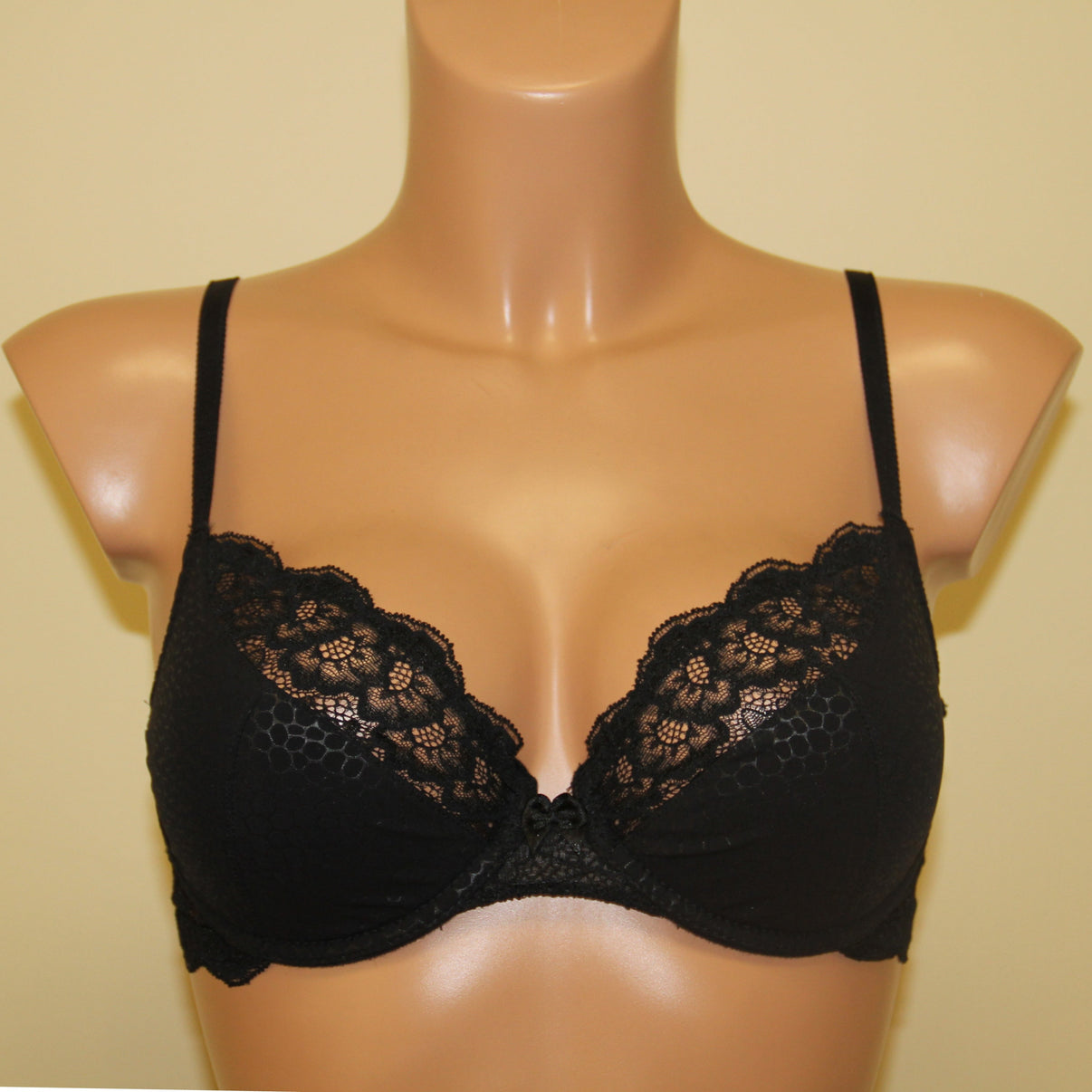 A black half padded bra with underwired support and lace detailing.