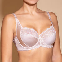 A beige-colored women's underwired bra with soft cups and extra foam side support, featuring adjustable straps and cotton lining inside the cups.